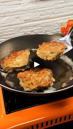 some food is being cooked in a frying pan on top of an orange stove