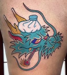 a tattoo on the back of a man's thigh with a dragon and ice cream cone