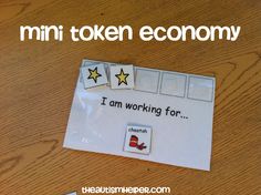 a piece of paper that says i am working for mini token economy on top of a wooden table