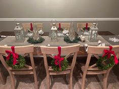 a dining room table with christmas decorations and candles on the top, surrounded by chairs