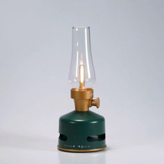 a green table lamp with a glass bulb on it's base and a brass spigot