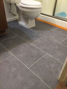 a white toilet sitting inside of a bathroom next to a walk in shower