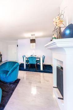 a living room filled with furniture and a fire place next to a dining room table