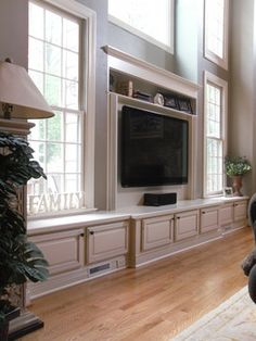 a living room filled with furniture and a flat screen tv on top of a wall