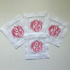 three monogrammed napkins with red and white stitching on each one side