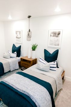 two beds in a room with blue and white pillows