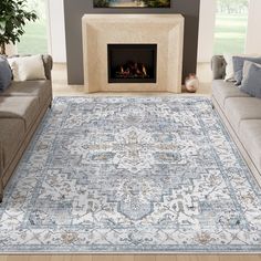 a living room area with couches and a rug on the floor in front of a fireplace