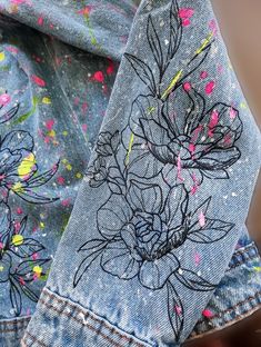 a pair of jeans with flowers painted on them