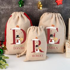 three bags with the letters p, d, and e on them sitting next to christmas decorations