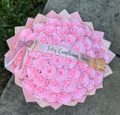 a bouquet of pink roses with a ribbon that says fifi's cupcakes here