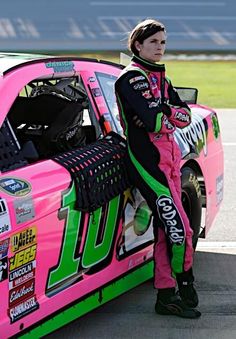 a woman leaning on the side of a pink car