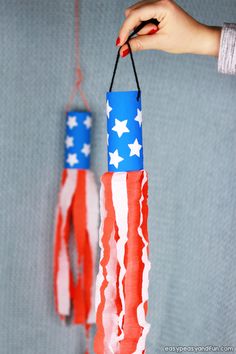 a person holding an american flag made out of toilet paper rolls and twine string