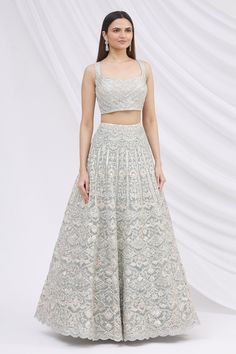 Grey lehenga with mirror and zari embroidered floral motifs. Comes with blouse and sheer dupatta.
Components: 3
Fabric: Net
Neckline: Square
Sleeve Length: Sleeveless
Color: Grey
Embroidery
Mirror and zari embroidered floral motifs on blouse
Deep back with tassel tie-up
Mirror and zari embroidered floral motifs on dupatta - Aza Fashions Grey Lehenga, Embroidered Bridal Lehenga, Sheer Dupatta, Grey Embroidery, Embroidery Mirror, Embroidered Lehenga, Bridal Lehenga, Floral Motifs, Set For Women