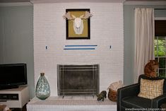 a living room filled with furniture and a flat screen tv mounted on a wall above a fire place