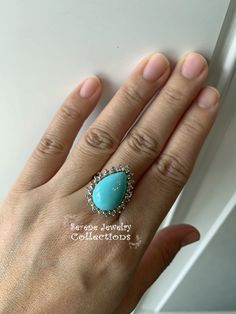 Pretty Levian Sleeping Beauty Turquoise diamond ring, This cabochon is cut in a cute teardrop shape and has a halo of round brilliant diamonds. Ring Size: 7 Total Weight: 8.31 grams Precious Metal: 14k yellow gold Precious stones: -Sleeping Beauty Turquoise Center Stone: 17mmx11.5mm, 13.8 carats -White Round Diamonds: 0.63 carats Hallmark: Levian, 14k Diamond Teardrop Jewelry With Accent Stones, Turquoise Diamond Ring As Gift, Turquoise Diamond Ring With Diamond Accents As Gift, Fine Jewelry Turquoise Ring With Diamond Accents, Turquoise Diamond Ring As A Gift, Teardrop Cabochon Jewelry For Anniversary, Formal Teardrop Turquoise Jewelry, Formal Turquoise Teardrop Jewelry, Anniversary Teardrop Cabochon Jewelry