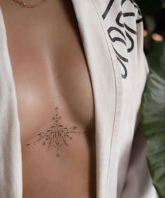 a woman's chest with a small tattoo on her left side and an arrow in the middle