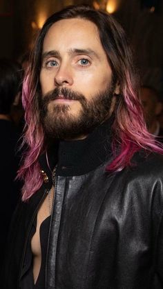 a man with pink hair and beard wearing a leather jacket