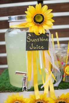 a table topped with mason jars filled with lemonade and sunflowers