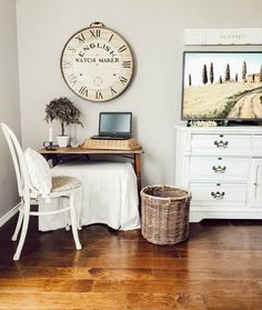 a room with a desk, chair and large clock on the wall above it's head