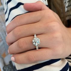 a woman's hand with a diamond ring on it