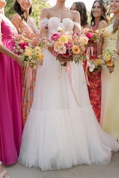 a group of women standing next to each other holding bouquets