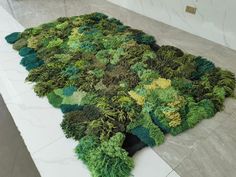 a rug made out of moss on the floor in a room with marble floors and walls