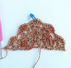 a crocheted doily with two knitting needles on the side and one hook in the middle