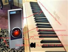 an electronic device sitting on top of a piano next to a keyboard with the words playing the piano below it