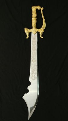 a gold and white knife on a black background