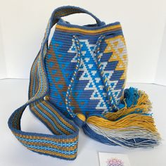 AVAILABLE FOR PREORDER ONLY. Allow 6-8 weeks to process. Special Edition AZULA Medium Bags. Unique and Stylish crochet bag! Very lightweight, durable and comfortable to carry on. Wear it as a cross-body or shoulder bag. These stunning boho style bags are perfect for a casual day, as a beach/pool accessory or as a complement to your sports outfit. Details: Bucket bag style Special Edition design with colorful and traditional patterns Double-thread & one needle crocheted Matching handmade single-t Bohemian Crochet Bucket Bag For Travel, Blue Bohemian Bucket Bag For Travel, Everyday Bohemian Crochet Bag With Adjustable Strap, Bohemian Crochet Travel Bag With Adjustable Strap, Crochet Crossbody Shoulder Bag For Travel, Travel Crochet Crossbody Shoulder Bag, Travel Crossbody Shoulder Bag With Crochet Details, Bohemian Yellow Crochet Shoulder Bag, Bohemian Crochet Bucket Bag For Everyday Use