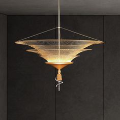 a modern chandelier hanging from the ceiling in a room with black walls and flooring