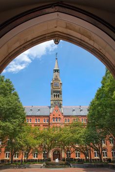 an archway leading to a large building with a clock tower in the middle of it