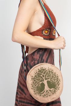 This Bohemian Round Crossbody Bag is the perfect accessory for your hippie spirit! The round shaped bag is made from a canvas material and features a beautiful printed design. It's the perfect accompaniment to festivals, beach days, and days spent exploring! The bag features a woven strap for easy carrying and a stunning tree of life, celestial and zodiac print. Sun and moon symbols as well as a butterfly decorate this bag making it an eye-catching piece. A zipper closure ensures all your belongings are safe, ready for you when you need them. Put on the Bohemian Round Crossbody Bag and get ready for an adventure! Details: Construction: 100% Cotton Dimension: 9 Inches H X 9 Inches L X 2.5 Inches W Belt Length: 60 Inches I Width- 1 Inches Entry: Zipper  Made in Nepal Bohemian Beach Bag Made Of Canvas, Bohemian Multicolor Canvas Bag, Bohemian Canvas Shoulder Bag For Beach, Bohemian Summer Bags With Adjustable Straps, Summer Festival Crossbody Bags, Festival Cotton Shoulder Bag With Adjustable Strap, Bohemian Cotton Crossbody Bag, Adjustable Bags For Summer Festivals, Hippie Bags For Everyday Summer Use