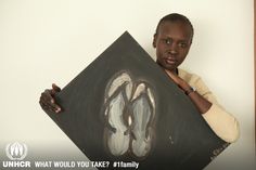 a young man holding up a painting in front of his face