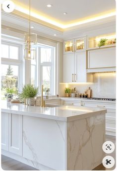 a kitchen with white cabinets and marble counter tops, along with an island in the middle