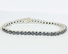 Unisex Tennis Bracelet Black Diamond 7.50 Inches In 925 Sterling Silver 4 mm AAA Diamond Color - Jet Black  Shape - Round Brilliant Cut  Size of Diamond - 4.00 mm  Weight of Diamonds - 12 carats appx. Length of Bracelet - 7.50 inches   Origin of Diamond - Central Africa (Conflict Free)  Species - Carbonado - Earth Mined  Quality - AAA  Metal - 925 Sterling Silver  CERTIFICATE OF AUTHENTICITY PROVIDED 100% Satisfaction guarantee WE SELL ONLY GENUINE DIAMOND. SOME MAY BE HEATED WHICH IS A COMMON AND ACCEPTABLE TREATMENT, OR BE FISSURE FILLED OR COLOR ENHANCED. WE DO NOT SELL SYNTHETIC OR LAB CREATED ITEMS AND ASSURE ALL DIAMOND ARE GENUINE. WE PROMISE 100% SATISFACTION GUARANTEE ON ALL PURCHASES. OUR GOAL IS QUALITY SERVICE, INTEGRITY AND COMPLETE CUSTOMER SATISFACTION. FOR ANY QUESTIONS DON Silver Certificate, Central Africa, Fine Jewelry Bracelets, Bracelet Black, Bracelets And Charms, Diamond Color, Tennis Bracelet, Round Brilliant Cut, Jet Black