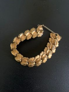 This elegant D'Orlan bracelet features articulated gold-colored links with gold-tone metal details. 7.5 inches in length with a folding clasp. Signed D'Orlan on the back with a serial number. In very good vintage condition D'Orlan was founded in 1957 in Toronto by Maurice Bradden, former student of Marcel Boucher. The manufacturing of D'Orlan jewelry is such that it was sold in department stores and high-end boutiques. Vintage Yellow Gold Link Bracelets, Vintage Yellow Gold Link Bracelet, Vintage Yellow Gold Hinged Bracelet, Vintage Gold Bracelet With Clasp, Vintage Gold-tone Jubilee Chain Bracelet, Vintage Gold Link Chain Bracelet, Vintage Link Gold Bracelet For Formal Occasions, Vintage Gold Link Bracelet For Formal Occasions, Vintage Antique Gold Bracelets For Formal Occasions