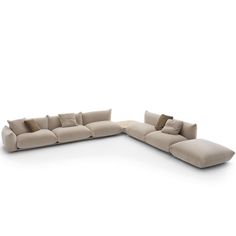 a large sectional couch with pillows on it's back and arms, in beige fabric