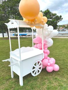 an ice cream cart with balloons attached to it