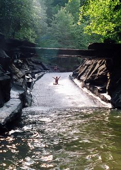 a person jumping into the water from a bridge