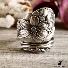 a silver flower ring sitting on top of a table