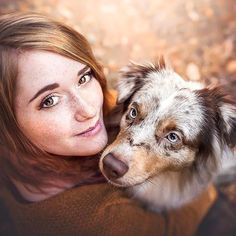 a woman with red hair hugging her dog