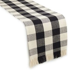 a black and white checkered table runner with fringes on it's edge