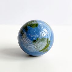 a blue and green ball sitting on top of a white table