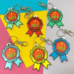 four keychains with different colored ribbons and numbers on them, one for the class of 2013