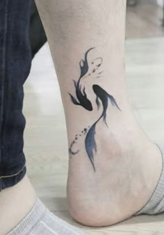 a black and white photo of a person's foot with a fish tattoo on it