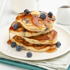 blueberry pancakes with syrup and bananas on a plate