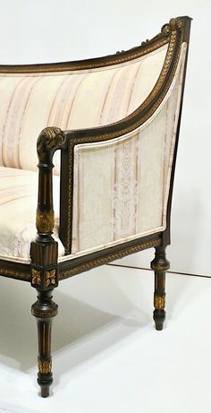 an antique style bed with white and gold fabric