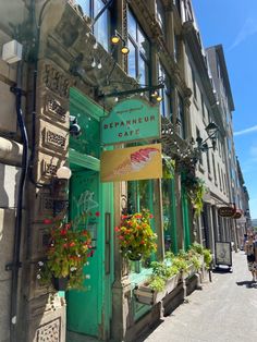 an old building with flowers in the window and a sign on the door that says, granneur cafe