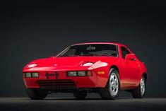 a red sports car parked in a dark room